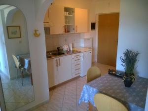uma cozinha com uma mesa, um lavatório, uma mesa e cadeiras em North Adriatic View Apartment em Rabac