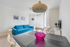 a living room with a table and a blue couch at Bursztynowe Osiedle Jantar, Sun & Snow in Jantar