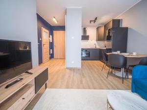 un soggiorno con TV e una sala da pranzo di Harmony Haven Apartament a Danzica