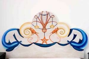 a large clock on a wall with blue tentacles at Palazzo Marzoli charme Resort - Small Luxury Hotel in Positano