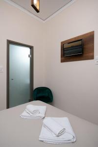 una habitación con una mesa con dos toallas blancas. en Olympic Hotel, en Moírai