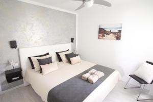 biała sypialnia z dużym białym łóżkiem z czarno-białymi poduszkami w obiekcie Apartment Portonovo Paraiso - Sea View - Piscina - Wifi - Old Town w Puerto del Carmen +32 zdjęcia