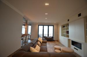 a living room with a brown couch and a table at Le Terrazze, Via Selvalunga 1, Stresa in Stresa