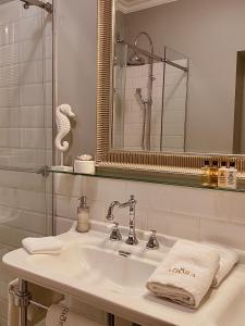 
a white sink sitting under a mirror in a bathroom at Adora Luxury Hotel in Bled
