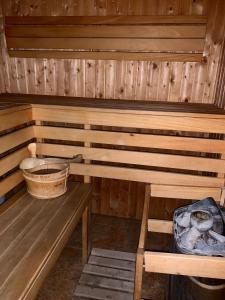 a wooden sauna with a bench and a bucket at Nocowanie Restauracja Wenecka in Kłobuck