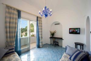 a living room with a chandelier and a table at Palazzo Marzoli charme Resort - Small Luxury Hotel in Positano
