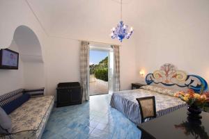 a bedroom with a bed and a couch and a table at Palazzo Marzoli charme Resort - Small Luxury Hotel in Positano