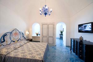 a bedroom with a bed and a chandelier at Palazzo Marzoli charme Resort - Small Luxury Hotel in Positano
