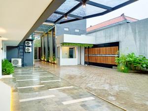 Kalibanteng-lor的住宿－Hotel Youstay Semarang by Sinergi，一个带庭院的房屋,设有车库