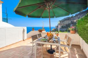 un tavolo e sedie con ombrellone su un patio di Villa Mare ad Amalfi