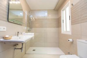 Baño blanco con lavabo y espejo en Hotel Ros Mary, en Ribadeo