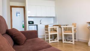 a living room with a couch and a kitchen at Apartamentos Turisticos Flamero in Matalascañas