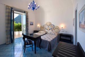 a bedroom with a bed and a table and a dining room at Palazzo Marzoli charme Resort - Small Luxury Hotel in Positano