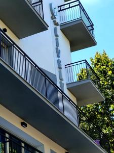 een gebouw met twee balkons en een klok erop bij Lively Hotel in Bellaria-Igea Marina