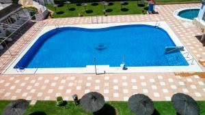 an overhead view of a large blue swimming pool at Apartamentos Turisticos Flamero in Matalascañas