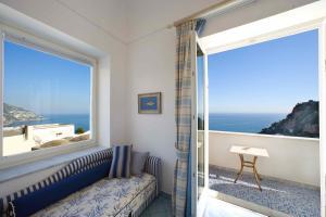 a room with a window with a view of the ocean at Palazzo Marzoli charme Resort - Small Luxury Hotel in Positano