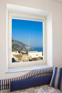 a window with a view of the ocean at Palazzo Marzoli charme Resort - Small Luxury Hotel in Positano