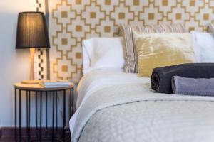巴塞隆納的住宿－復古出租酒店，一间卧室配有一张床和一张桌子上的台灯