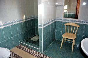 a bathroom with a chair and a tub and a toilet at Gábor apartmanok in Abádszalók