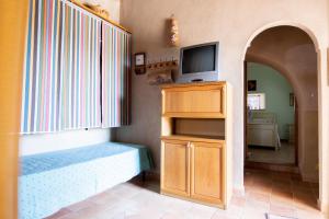 un soggiorno con TV, divano e TV di Case Vacanze La Venere a Rocca Imperiale