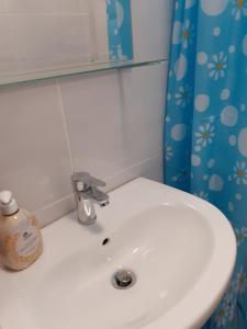 a white sink in a bathroom with a blue shower curtain at VILA IRINA in Mangalia +24 photos