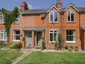 a brick house with white windows and plants at Meadow View in Banbury