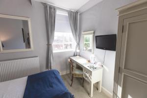 a bedroom with a desk and a bed and a window at The Old Vicarage Hotel & Restaurant in Bridgwater