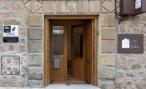 una entrada a un edificio de piedra con puertas de madera en Apartamento Imón en ElMolinoDeLaSal de Sigüenza, en Sigüenza