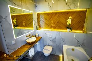 a bathroom with a sink and a toilet and a tub at Baltic Apartments - Platan Tower in Świnoujście