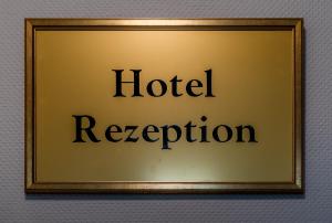 una imagen de un cartel de recepción del hotel en una pared en Hotel Meyer, en Bergheim
