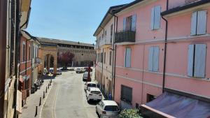 une rue de la ville avec des voitures garées à côté des bâtiments dans l'établissement RomagnaBNB Dal Mazareta, à Forlimpopoli