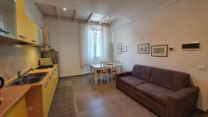 sala de estar con sofá y cocina con mesa en RomagnaBNB Dal Mazareta, en Forlimpopoli