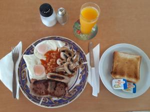 a plate of breakfast food with eggs sausage beans and toast at Sunquest Gardens Holiday Resort in Limassol