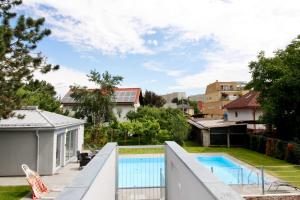een achtertuin met een zwembad en een huis bij Modern Balcony Apartment with Pool close to Lake in "Donaustadt" in Wenen