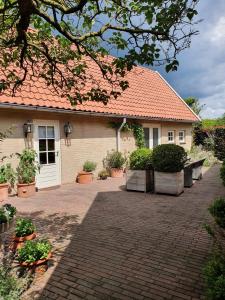 a house with a brick driveway in front of it at Chapeau ! in Garderen