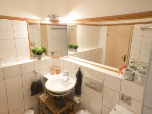 ein Badezimmer mit einem Waschbecken, einem WC und einem Spiegel in der Unterkunft - NEU - LUXUS Frankfurt Flat in Obertshausen