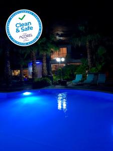 a swimming pool at night with a sign that reads clean and safe at Quinta Da Bela Vista in Ponta Delgada