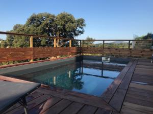 a swimming pool on a deck with a wooden fence at Between the Mountains and the Sea Villa w pool in Cauro