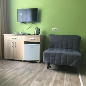 ノヴォシビルスクにあるPrimorye Hotelのリビングルーム(椅子、薄型テレビ付)