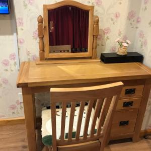 a wooden dressing table with a mirror on it at Cascades Motor Lodge in Auckland