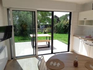 a kitchen with a large sliding glass door with a table at ETABLISSEMENT CHEZ JULES in Ambleteuse