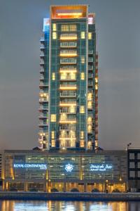 a tall building with lights in front of it at Royal Continental Suites Business Bay - Deluxe Apartments in Dubai