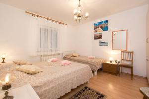 una camera con due letti, un tavolo e uno specchio di Apartment Stefano a Vrh
