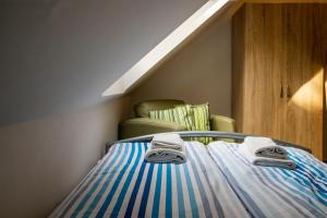1 cama con toallas y 1 silla en una habitación en Dollár Apartman en Orfű