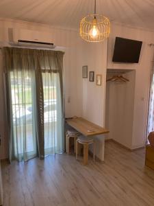 een woonkamer met een houten tafel en een televisie bij Sealake View in Mesolongion