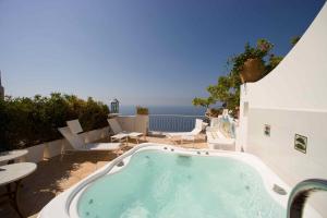 a hot tub on a patio with a view of the ocean at Palazzo Marzoli charme Resort - Small Luxury Hotel in Positano