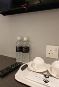 a counter with two bottles of water and a remote control at Suite Dreamz Hotel Banting in Banting
