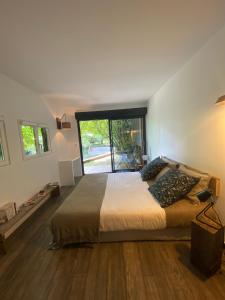 1 dormitorio con cama grande y ventana grande en La Cabane de Troyes - Chambre d'hôtes, en Troyes