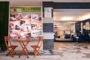 duas cadeiras e uma mesa em frente a uma loja em Persimmon Hotel em Hsinchu