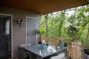 a screened in porch with a table and chairs at CHALET MAAIKE in Durbuy